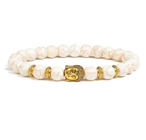 Closeup of the 8mm white stone bead bracelet showing the detailed golden Buddha head charm.
