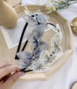Vista detallada de una diadema de mariposa bordada con detalles de pedrería y encaje