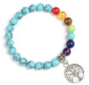 Detailed shot of the 8mm chakra turquoise gemstone bracelet with silver tree of life pendant.