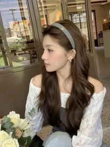 Close-up of a French vintage grey headband with a small gold heart on a model.