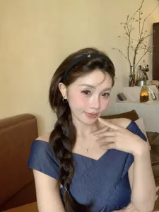Elegant French vintage black headband with a small gold heart detail worn by an Asian model