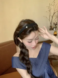Close-up of a French vintage black headband with a gold heart detail on an Asian model