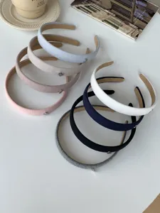 Detailed view showing seven assorted colored fabric headbands with small heart accents