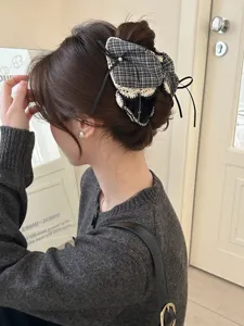 Detailaufnahme einer karierten Haarspange im koreanischen Stil mit Spitzenschleife