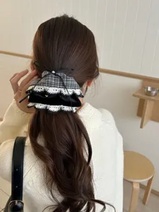 Detail eines koreanischen Haaraccessoires mit Hahnentrittmuster, Spitze und Schleife