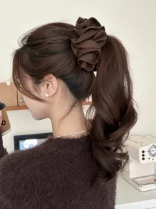 Elegant coffee brown flower hair clip securing a wavy ponytail in a cozy cafe setting.