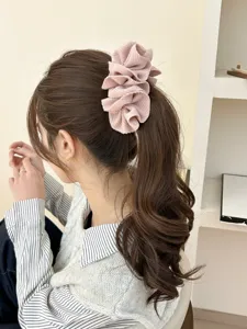Close-up view of a pink oversized textured flower banana hair clip on a ponytail