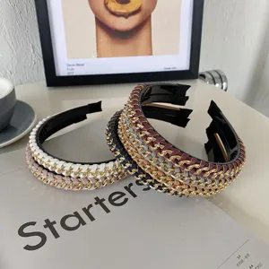 Close-up detail of braided PU leather and golden alloy chain headbands on a magazine