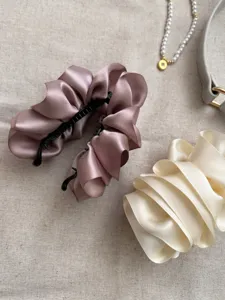 Detail view of satin ruffled bubble flower banana hair clips in mauve and cream