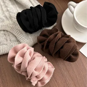 Set of three textured knit banana hair clips in black brown and pink colors for women.