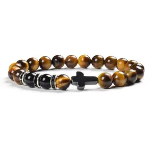 Detailed view of 8mm yellow tiger eye and black stone beaded bracelet with cross charm.