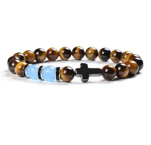 Detailed close-up view of the natural tiger eye gemstone beads and cross pendant bracelet charm.