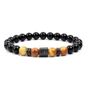 Close-up detail of beaded gemstone bracelet with black stones and paved zircon charm.