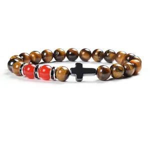 Detail of 8mm yellow tiger eye stone and red agate beaded bracelet with metal cross charm.