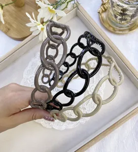Macro detail view of three glossy plastic chain-link headbands in earthy tones