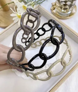Detailed view of stylish plastic chain link headbands in various neutral colors.