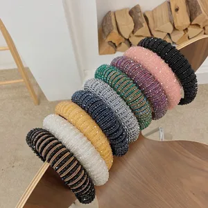 Detail view of multicolored Baroque crystal beaded wide headbands on a wooden chair.