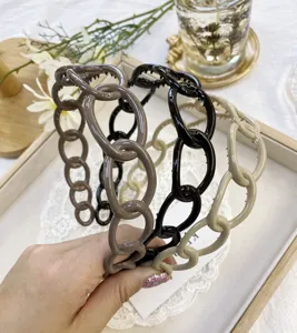 Detail showing three chain-link plastic headbands in coffee, black, and beige colors.