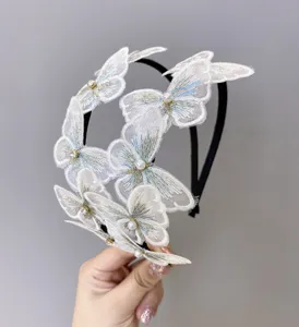 Primer plano de diadema de mariposas bordadas blancas con perlas y pedrería