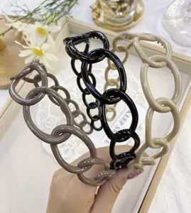 Detailed view showing plastic chain link headbands in brown, black, and beige tones.