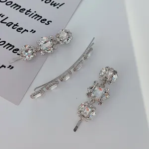 Close-up of three elegant silver-toned hair clips with sparkling clear rhinestones