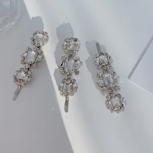 Macro detail of three elegant silver-toned hair clips with clear sparkling rhinestones