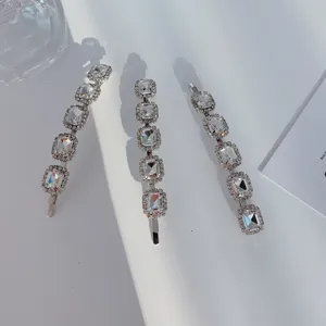 Detailed view of three silver alloy hair clips set with sparkling clear rhinestones