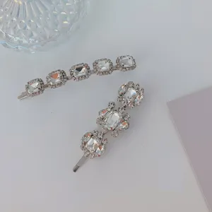 Close-up detail of elegant silver bobby pins featuring sparkling square crystal rhinestones