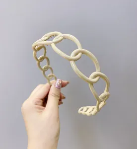 Detailed view of a minimalist cream plastic chain-link headband with non-slip teeth
