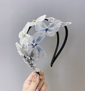 Detalles que muestran los delicados motivos de mariposas bordadas en una diadema con strass