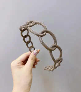 Detailed macro shot of a glossy mocha brown plastic chain-link headband with anti-slip teeth.