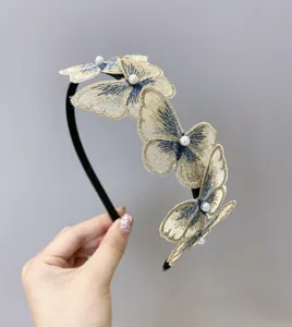 Primer plano de diadema de mariposa bordada con perlas y detalles azules