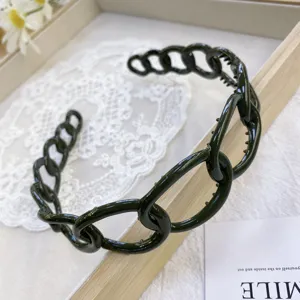 Macro detail of a glossy dark green plastic chain link headband with non-slip teeth
