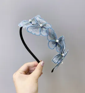 Detalle de una diadema de mariposas azules bordadas con detalles de perlas para niñas