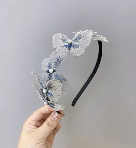 Detalle de una elegante diadema de mariposa con perlas y unos bordados delicados