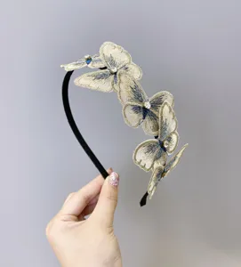 Vista detallada de una elegante diadema de mariposas bordadas con detalles de diamantes