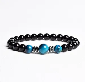 Detailed view of the beaded bracelet with black and blue stones and metallic spacers.