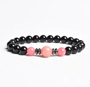 Close-up detail of the beaded bracelet featuring black and pink stones with metallic spacers.