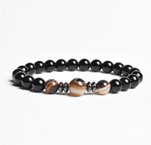 Black bead bracelet with striped agate and metal spacers, elegant and stylish jewelry item.