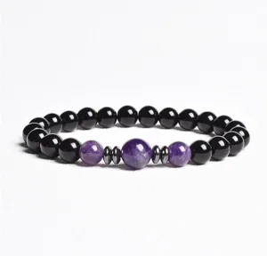 Close-up detail of black bead and purple crystal gemstone stretch bracelet with spacers.