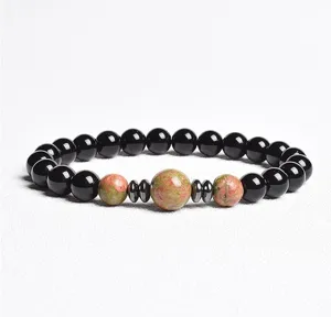 Close-up of 8mm black bead unakite spacer bracelet detail showing natural stone texture.