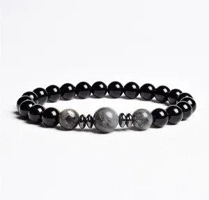Detailed view of beaded bracelet with black onyx, grey stone beads and metallic spacers.