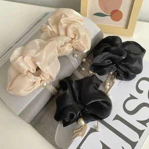 Elegant detail van grote organza haarelastiekjes met parels en kristallen franjes.