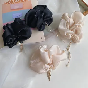 Detail of elegant organza scrunchies with long dangling pearl and rhinestone tassels