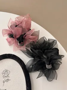 Detailweergave van fonkelende mesh scrunchies met strass-accenten in zwart en mauve