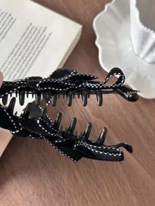 Detailed close-up of a vintage black velvet bow hair claw clip with white dots