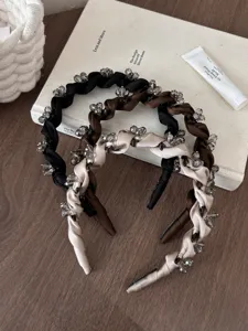 Detailansicht hochwertiger, mit Kristallen besetzter Haarbänder in Schwarz und Braun