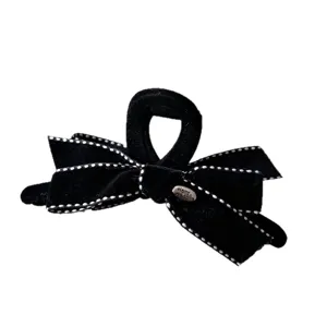 Elegant black velvet bow hair claw clip with white dotted edges and handmade metal tag.