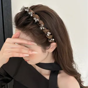 Eleganter brauner Satin-Haarreif mit funkelnden Kristallverzierungen an einem Modell