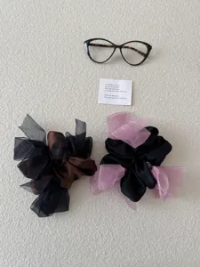 Detailopname van elegante satijnen en organza scrunchies met strikken